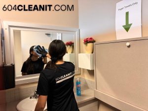 a girl cleaning the mirror of the bathroom